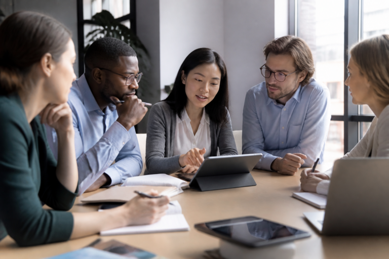 Groupe de salariés en formation professionnelle en réunion, utilisant carnet et tablette