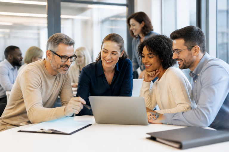 Groupe de personnes en formation professionnelle collaborant autour d’un ordinateur en salle moderne