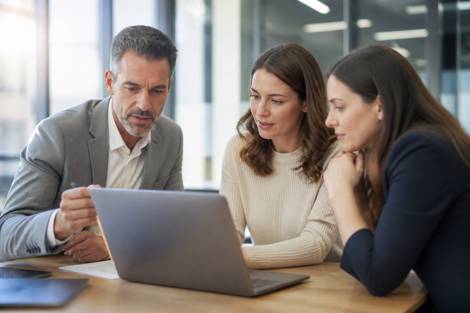 Réunion de travail avec manager et RH analysant un dossier de formation sur ordinateur