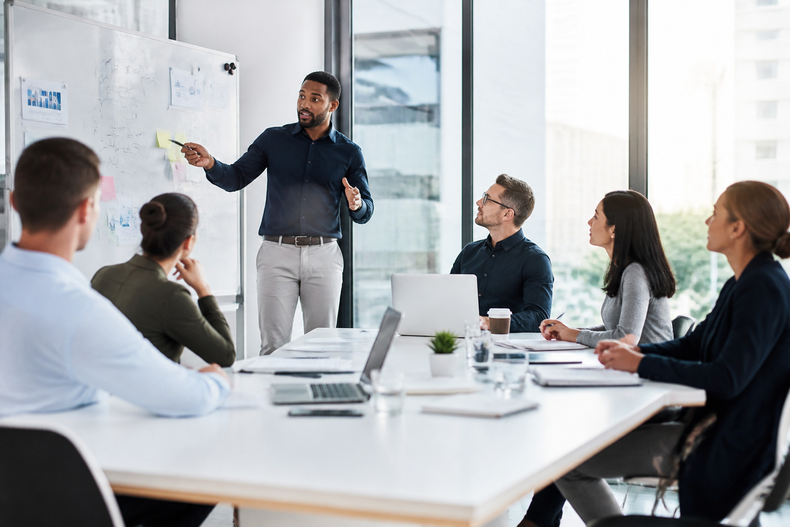 Manager expliquant des concepts en réunion devant une équipe attentive
