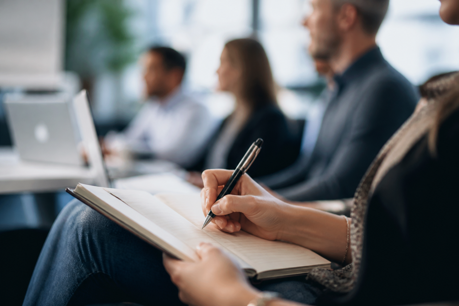 Détail main prenant des notes sur carnet pendant formation professionnelle
