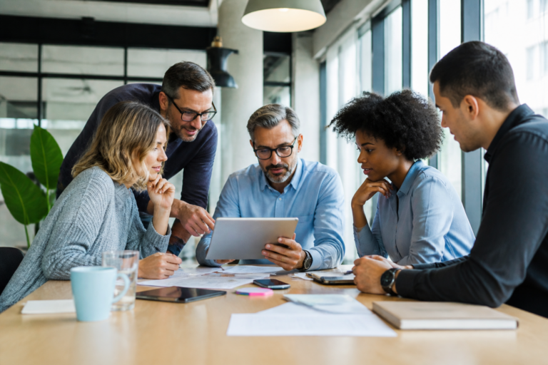 Professionnels en formation continue en réunion collaborative avec une tablette numérique
