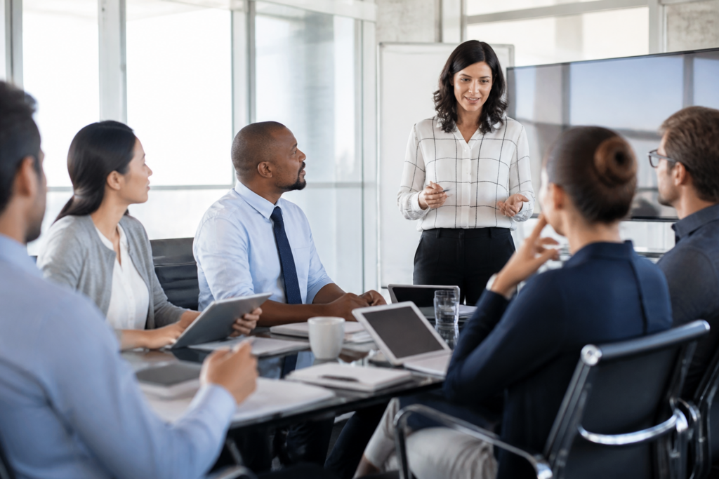 Personnes en formation professionnelle réunies autour d'une table moderne avec des tablettes et carnets
