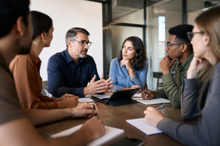 Réunion de travail en formation professionnelle avec participants échangeant autour d'une table