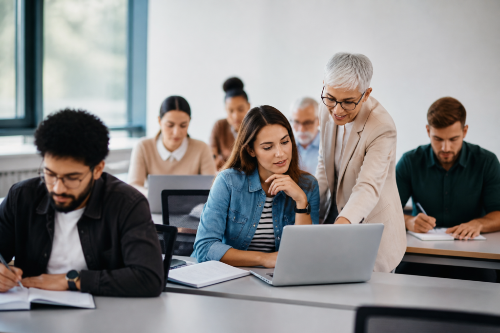 Groupe de personnes en formation professionnelle en salle moderne avec ordinateurs et carnets