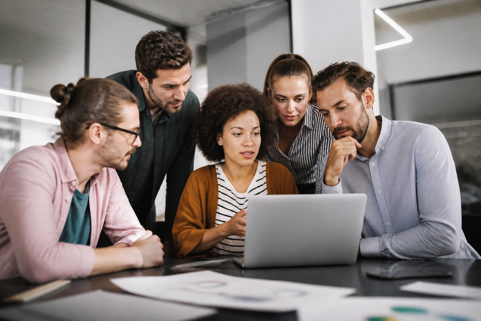 Professionnels en atelier de formation digitale collaborant sur un ordinateur portable